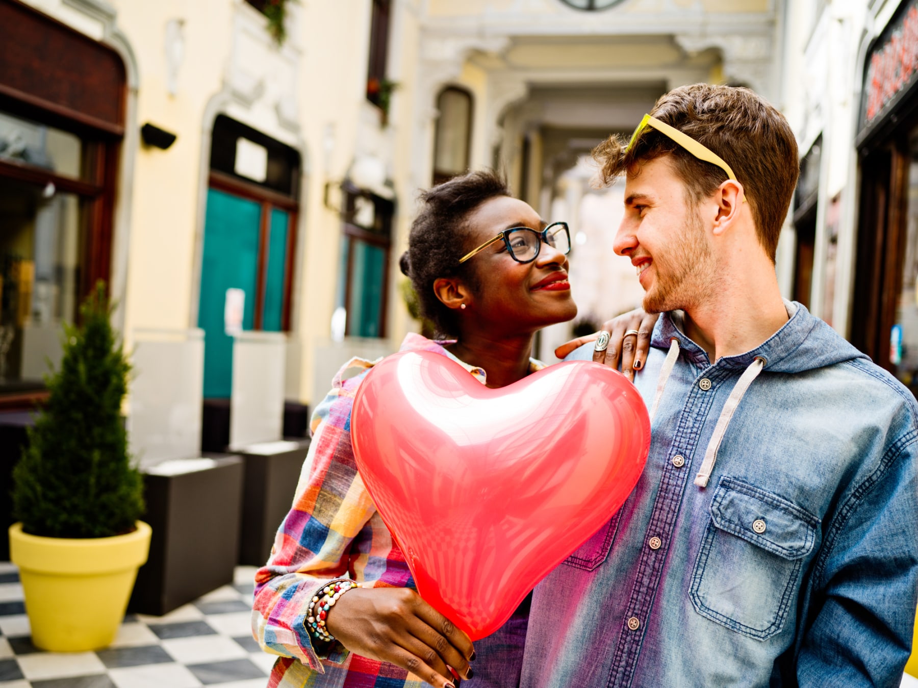 Happy couple holds heart-shaped balloon.